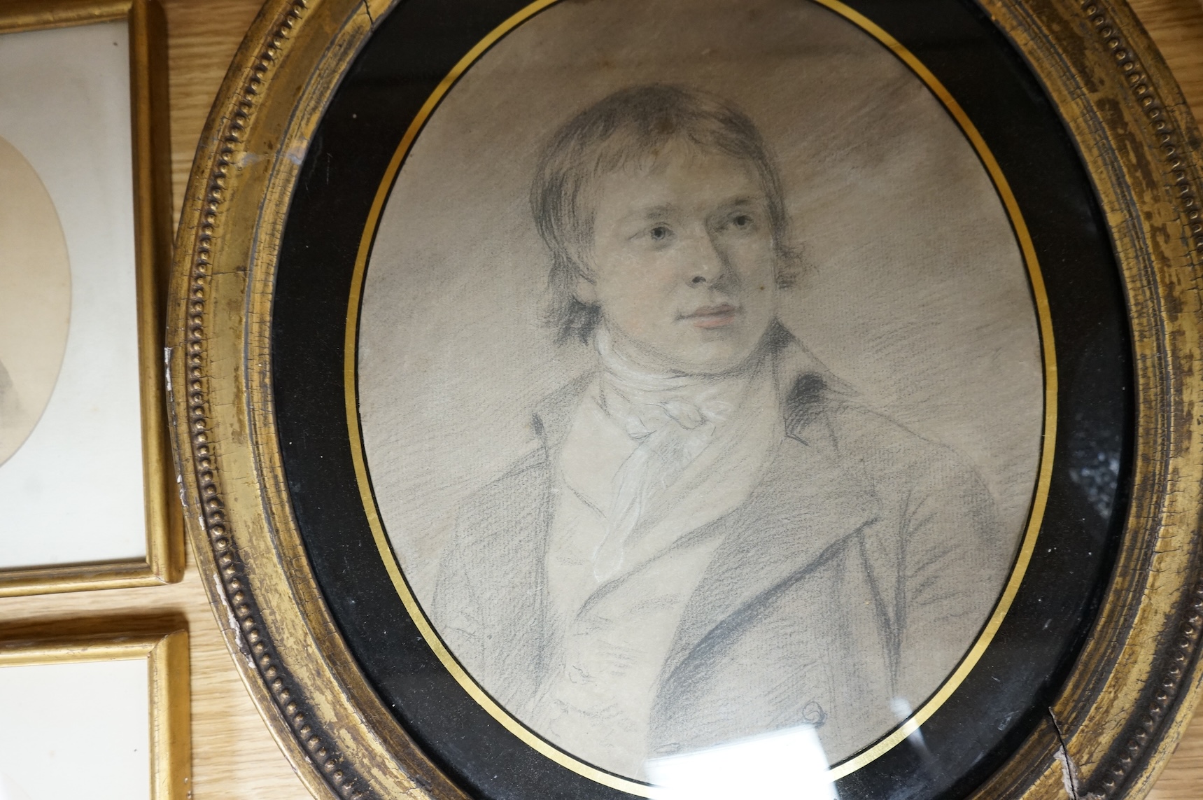 Four Regency and early Victorian portraits to include a pair of a lady and gentleman together with a carved wax bust of a lady wearing a bonnet, housed in an ebonised and gilt oval box frame, largest overall 38 x 32cm